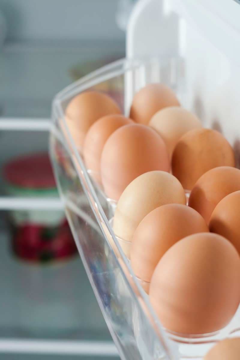 Eier im Eierfach der Kühlschranktür. Alle zeigen mit der Spitze nach unten.