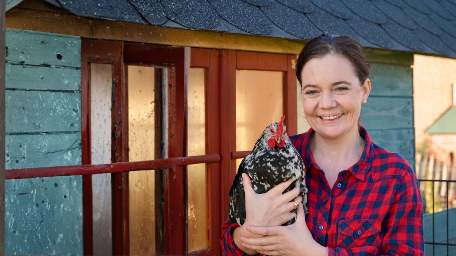 Dr. med. vet. Eva-Maria Casteel mit einem ihrer Hühner vor dem Stall